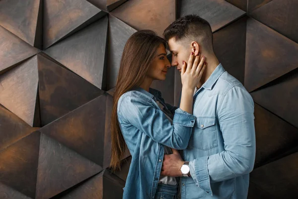 Jong stijlvolle koppel in jeans kleding in de buurt van een houten vintage muur — Stockfoto