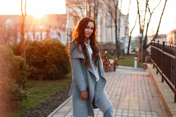 Belle femme dans un manteau élégant un jour de printemps au coucher du soleil — Photo