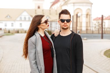 Yakışıklı adam sokakta poz şık güneş gözlüğü ile moda giysiler içinde güzel bir kadınla.