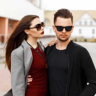 Şık moda giysileri sokakta güneş gözlüklü genç güzel Çift.