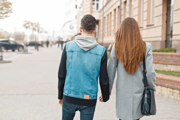 Genç çift şehirde yürüyüş arkadan görüntülemek
