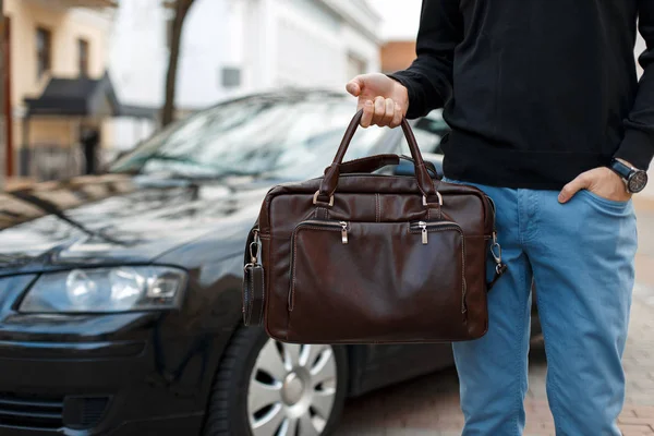 Man businessman with leather bag near a black car — Stock Photo, Image
