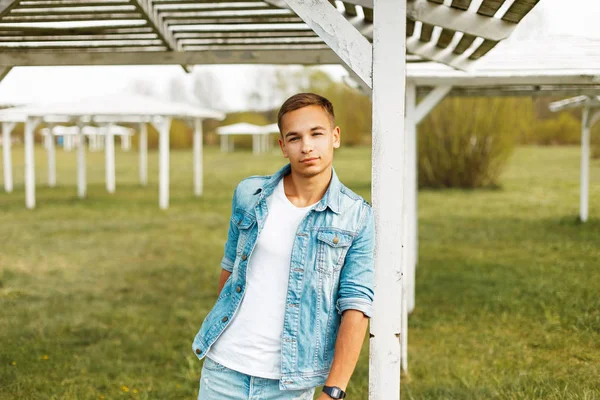 Yakışıklı delikanlı denim ceket ve Beyaz gömlekli açık havada