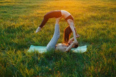 Genç çift pratik Yoga üzerinde güzel bir gün batımı. Sağlıklı yaşam tarzı