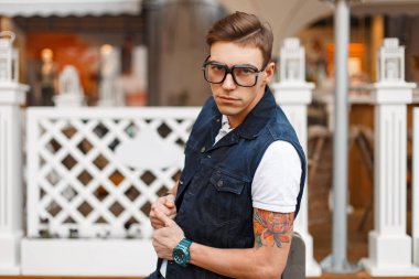 kot giyim ve moda gözlük ahşap bir çit yakınındaki yakışıklı genç