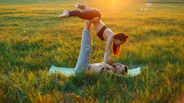 Couple practicing yoga at sunset. The concept of a healthy lifestyle — Stock Photo, Image