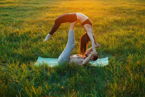 Genç çift pratik Yoga üzerinde güzel bir gün batımı. Sağlıklı yaşam tarzı