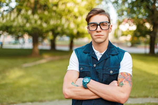 Vintage gözlük ve kot yelek bir yaz gününde Park ile yakışıklı genç
