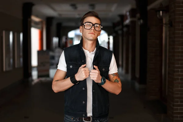Building yakınındaki bir kot yelek gözlüklü moda yakışıklı adam — Stok fotoğraf