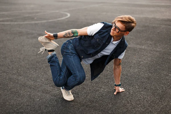 Joven hombre guapo en elegante vestido de mezclilla bailando hip hop — Foto de Stock