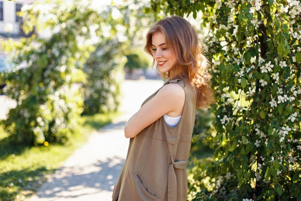 Vacker ung glad kvinna i moderiktiga kläder i parken — Stockfoto