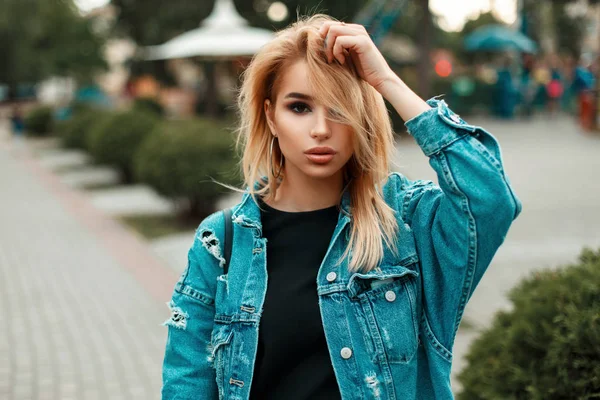 Menina loira nova bonita com cabelo em roupas jeans no parque em um dia de verão — Fotografia de Stock