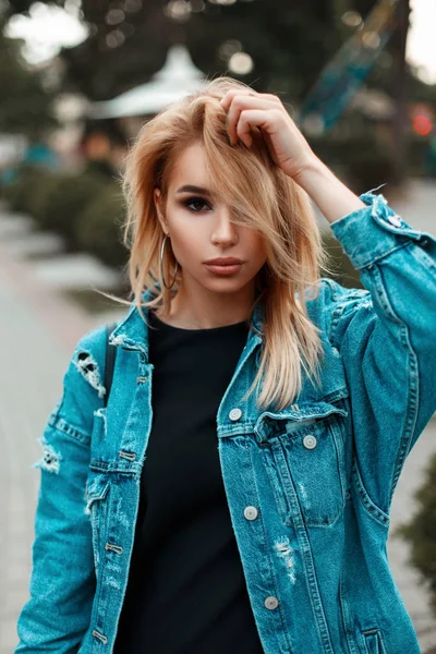 Retrato de moda de una hermosa joven en ropa de mezclilla en el parque —  Fotos de Stock