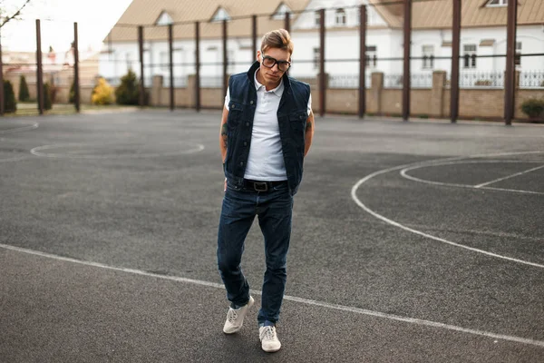 Yakışıklı genç adam gözlüklü vintage kot tarzı street yürüyüş