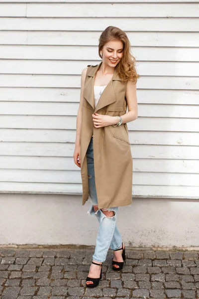 Mujer feliz con una linda sonrisa en ropa de moda cerca de una pared de madera —  Fotos de Stock