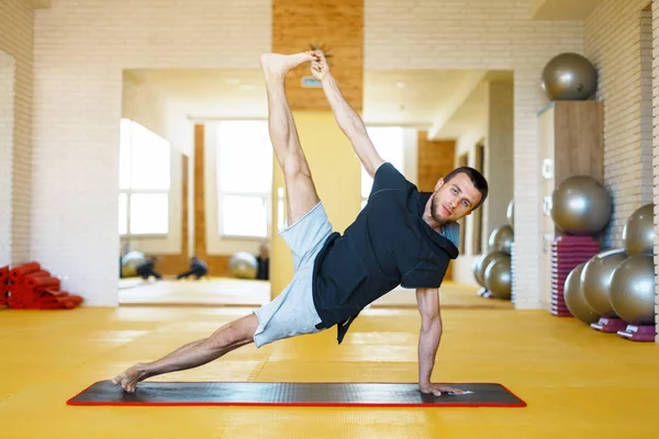 Genç adam spor salonunda yoga yapıyor. — Stok fotoğraf