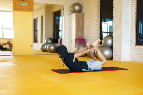 Yoga uygulamak ve sarı Studio'da germe yapıyor genç modern erkek — Stok fotoğraf