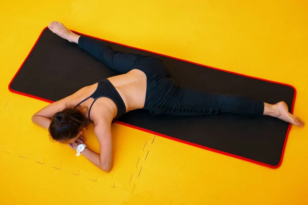 Jovem mulher saudável fazendo fitness e alongamento no amarelo — Fotografia de Stock
