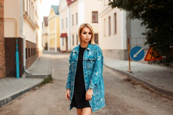 Mulher bonita na moda em uma jaqueta de calça que anda ao ar livre em um dia de verão — Fotografia de Stock