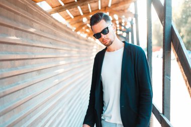 Güneş gözlüklü bir güneşli yaz gününde bir saç kesimi ile şık yakışıklı adam