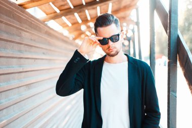 Güneşli bir günde güneş gözlüklü trendy kıyafetler şık genç iş adamı