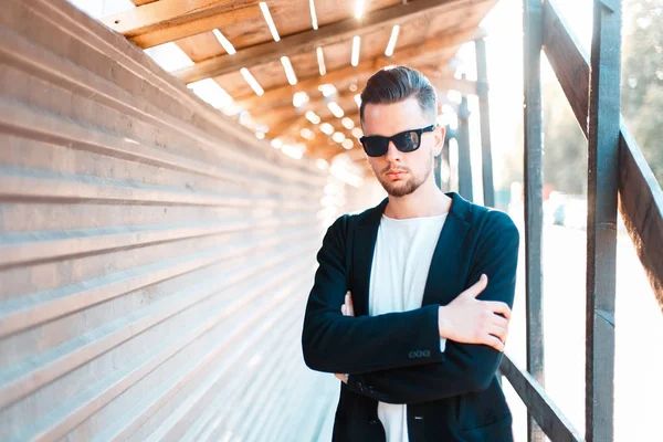 Junger Geschäftsmann mit Sonnenbrille posiert an einem sonnigen Tag in der Nähe einer Metallwand — Stockfoto