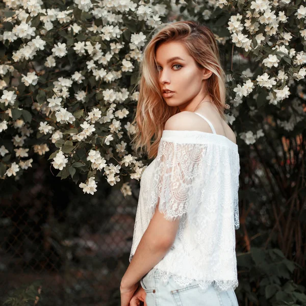 Hermosa joven americana modelo mujer en vestido de encaje blanco cerca de flores —  Fotos de Stock