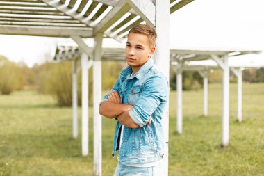 Moda yakışıklı genç kot pantolon giysili bir plaj gölgelik standları