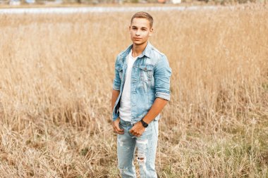 Kırsal yakışıklı genç Kot ceket ve kot pantolon alanına yürüyor