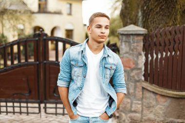 Şık yakışıklı delikanlı bir özel evden Beyaz gömlekli kot pantolon giysili