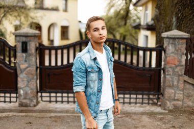 Kot pantolon vintage giyim ahşap bir çit yakınındaki şık genç adam