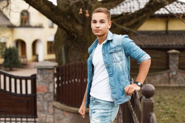 Denim ceket ve kot bahçedeki şık yakışıklı delikanlı