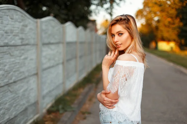 Feliz bela mulher loira em um top de renda branca ao ar livre — Fotografia de Stock