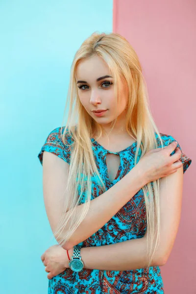 Hermosa joven en vestido azul con adorno cerca de una pared brillante —  Fotos de Stock