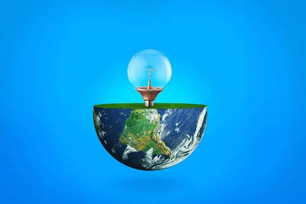 Žárovka a planeta Země na modrém pozadí. Pojem ekologie — Stock fotografie