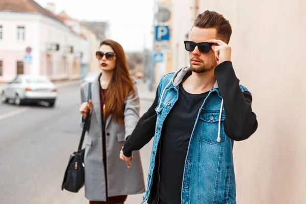 Молода красива пара в сонцезахисних окулярах йде на вулицю — стокове фото