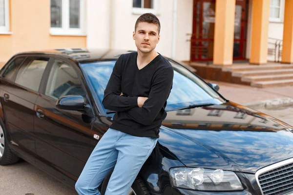 Homem bonito em uma camiseta preta perto do carro — Fotografia de Stock