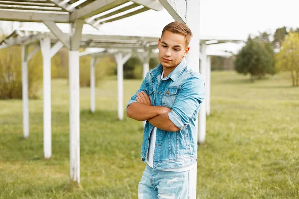 Doğa bir ahşap beyaz gölgelik yakınındaki kot pantolon giysili yakışıklı adam