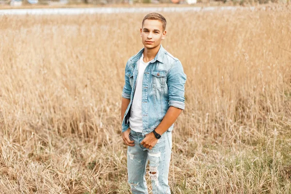 Kırsal yakışıklı genç Kot ceket ve kot pantolon alanına yürüyor