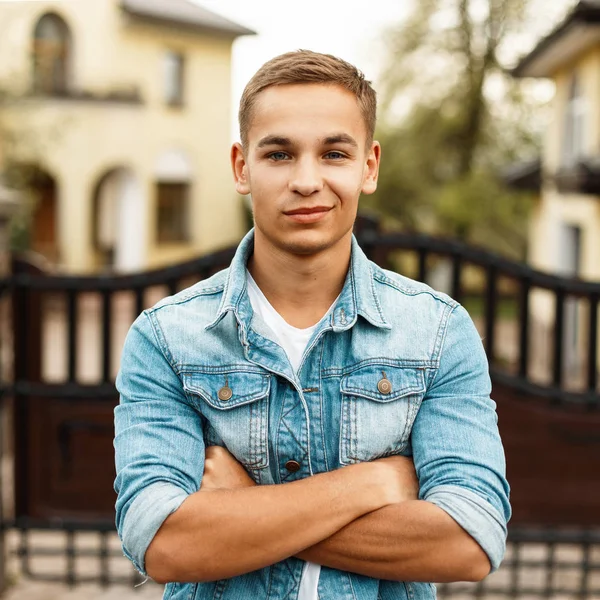 Mutlu, güzel bir genç adam bir kot ceket ve Beyaz tişört, açık havada portresi