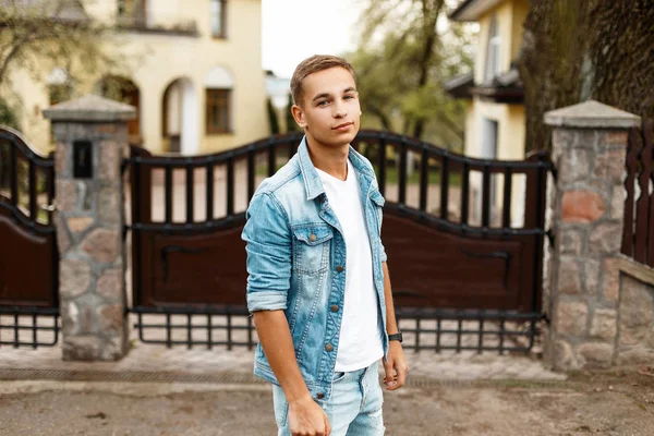 Kot pantolon vintage giyim ahşap bir çit yakınındaki şık genç adam