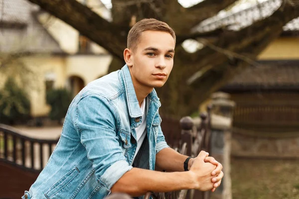 Kot elbise şık yakışıklı ve Beyaz tişört bir house Bahçe civarındaki oteller