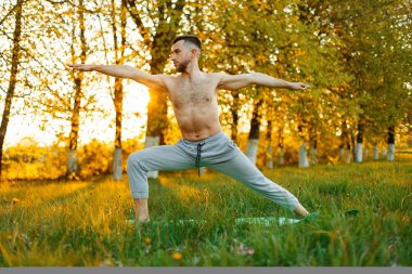 Adam pratik Yoga bahar parkta günbatımında. Sağlıklı yaşam tarzı