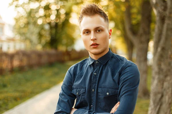 Retrato de un joven guapo con una elegante camisa azul en el parque — Foto de Stock