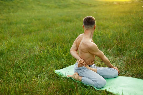 Man practicing yoga in the green park — Stock Photo, Image