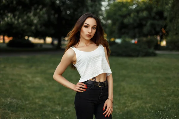 Красива молода жінка в літньому одязі позує в парку — стокове фото
