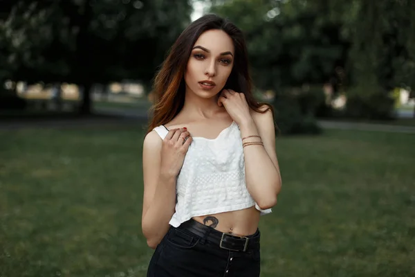 Hermosa mujer sexy con una camiseta blanca posando en el parque — Foto de Stock