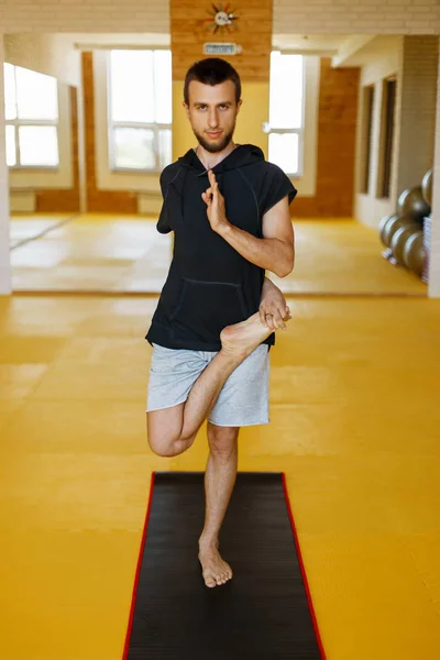 Człowiek robi joga na siłowni — Zdjęcie stockowe