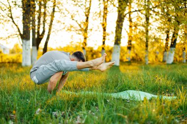 gün batımında pratik Yoga Park adam. Sağlıklı yaşam tarzı