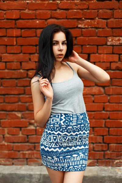 Piękna Młoda Dziewczyna Brunetka w letnie ubrania w pobliżu ściany z czerwonej cegły — Zdjęcie stockowe